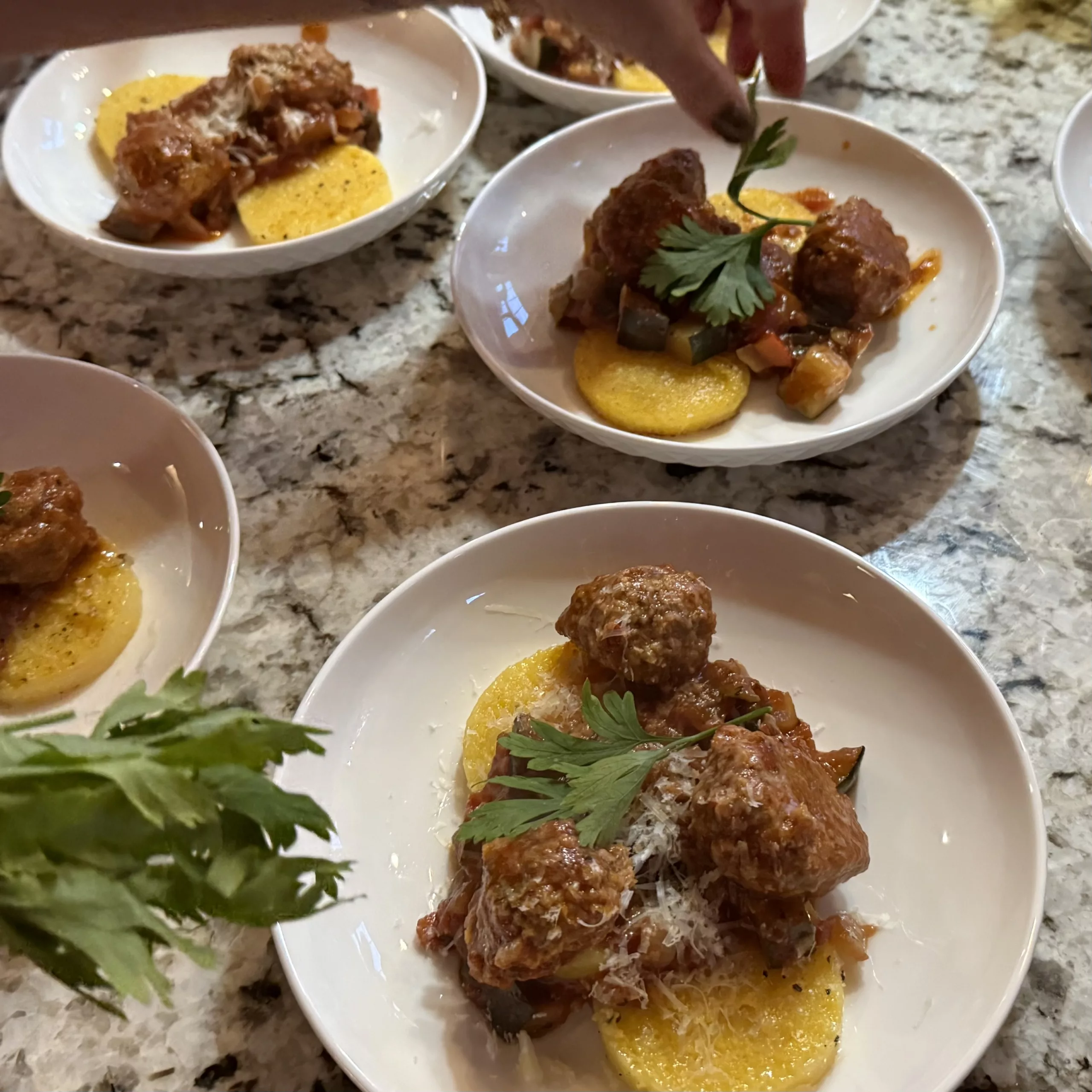 Garnishing meatballs with fresh herbs